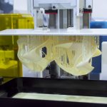 Printed models on 3D printer close-up. Objects printed on photopolymer sla 3D printer from liquid photopolymer resins on printing platform. Modern progressive additive technology. 3D printer printing